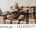 Mature woman learning to play guitar at home 141439377