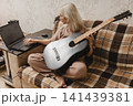 Mature woman learning guitar with a laptop at home 141439381