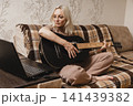 Mature woman learning guitar with a laptop at home 141439382