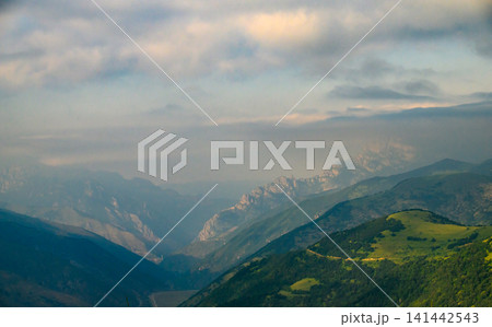 Aerial view of mountainous terrain with rolling green slopes Aerial view of mountainous terrain with rolling green slopes 141442543