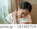 Cropped shot view of Asian woman having shoulder and neck pain from working longtime. Shoulder pain is when rotator cuff tendons become inflamed or trapped in your shoulder. 141442729