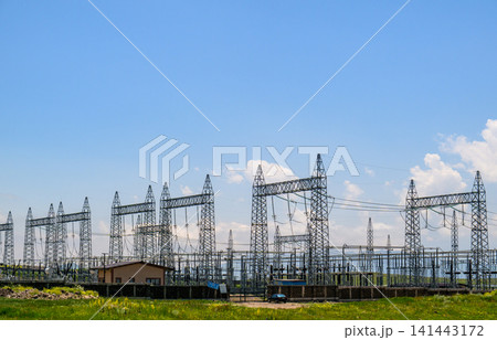Rows of tall electrical towers stand against bright sky 141443172