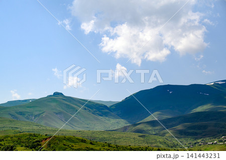 Rolling green hills with valley and distant ridge Rolling green hills with valley and distant ridge 141443231