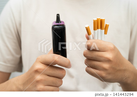Man holding electronic cigarettes, no smoking. Man holding electronic cigarettes, no smoking. 141443294