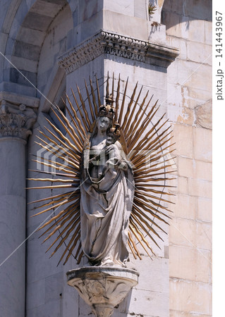 Virgin Mary with baby Jesus, statue on the corner of the facade of the San Michele in Foro Church in Lucca, Italy 141443967