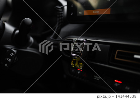 Car air freshener attached to the ventilation grill on a dashboard. Car air freshener attached to the ventilation grill on a dashboard. 141444339