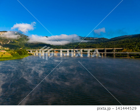 Bridge crosses river under blue sky and clouds in daytime Bridge crosses river under blue sky and clouds in daytime 141444529