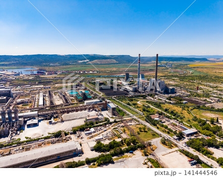 View of industrial area showing power plant and surrounding landscape during sunny day View of industrial area showing power plant and surrounding landscape during sunny day 141444546