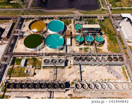 Industrial site shows large tanks and machinery at a processing facility in a rural area during daylight hours Industrial site shows large tanks and machinery at a processing facility in a rural area during daylight hours 141444642