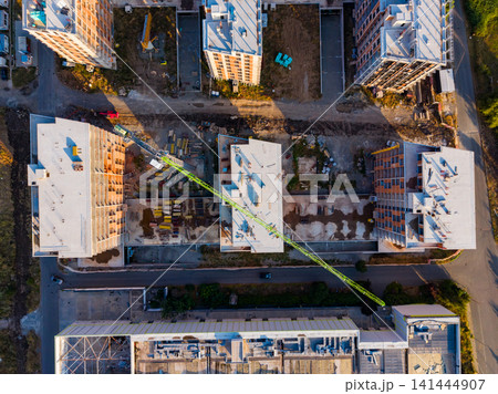 Construction site view in a city with multiple buildings and a crane during daylight 141444907