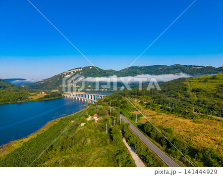 Scenic view of a bridge over water with hills and clear sky in the background during daytime 141444929