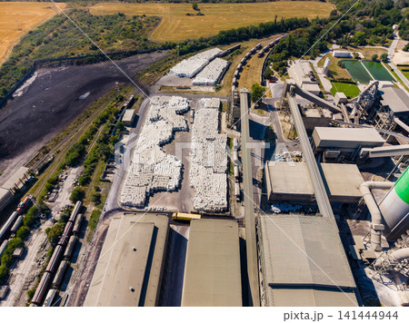 Industrial site with large storage area and machinery in the countryside during daylight hours Industrial site with large storage area and machinery in the countryside during daylight hours 141444944