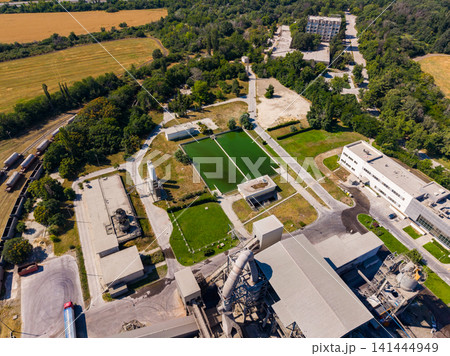 View of an industrial area with green spaces and buildings in a rural setting View of an industrial area with green spaces and buildings in a rural setting 141444949