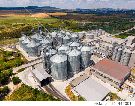 Large storage facility with silos and agricultural land viewed from above during daylight hours 141445001