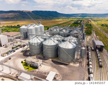 Large storage silos and railway near fields in rural area during daytime Large storage silos and railway near fields in rural area during daytime 141445037