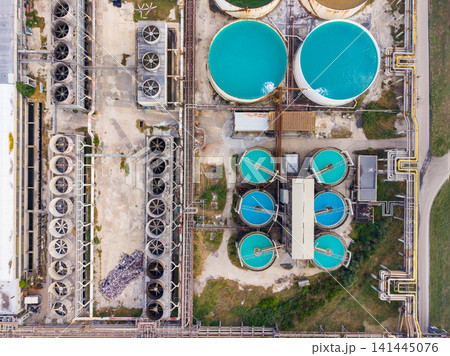 Water treatment facility in operation, showing multiple tanks and equipment during daylight hours Water treatment facility in operation, showing multiple tanks and equipment during daylight hours 141445076