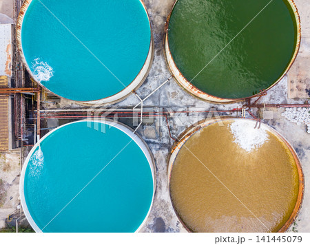 Water tanks in different colors at a treatment facility during daylight 141445079