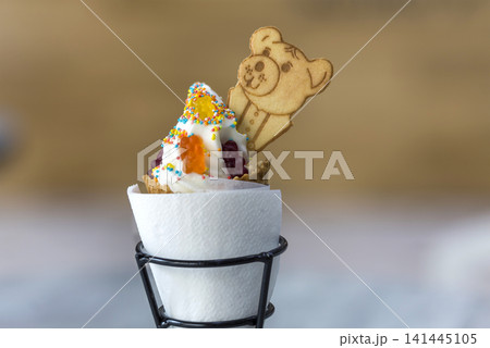 Ice cream cone dessert with cookies creative decoration topping on blurred light copy space background. 141445105