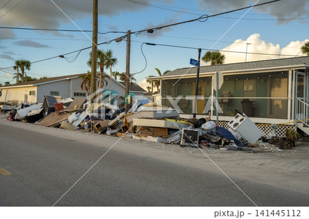 Hurricane damage in Florida. Piles of rubbish on street side from destroyed houses. Consequences of natural disaster Hurricane damage in Florida. Piles of rubbish on street side from destroyed houses. Consequences of natural disaster 141445112
