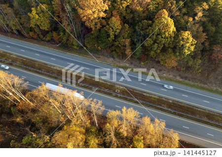 Highway road in North Carolina Appalachian mountains in fall season. Expressway lanes for fast passing of car traffic Highway road in North Carolina Appalachian mountains in fall season. Expressway lanes for fast passing of car traffic 141445127