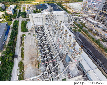 Industrial facility with multiple pipes and machinery located in a manufacturing area during daytime Industrial facility with multiple pipes and machinery located in a manufacturing area during daytime 141445227