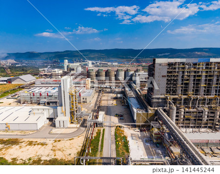 Factory complex with storage tanks and pipelines in the industrial area on a clear day Factory complex with storage tanks and pipelines in the industrial area on a clear day 141445244