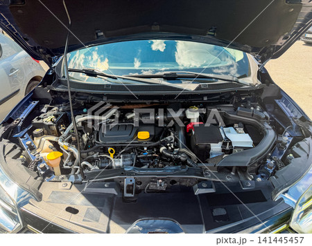 Car engine open for inspection at a parking lot in bright daylight 141445457