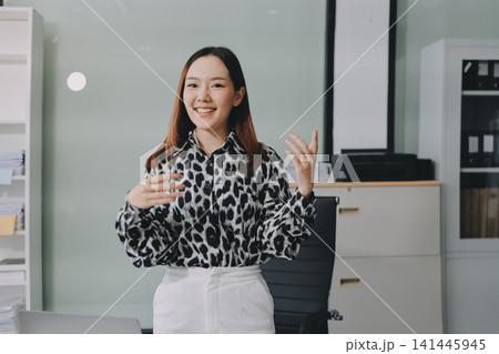 Confident asian business woman standing in modern office Confident asian business woman standing in modern office 141445945