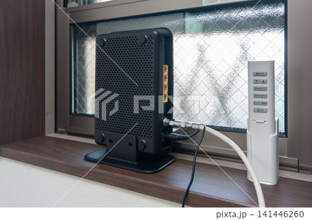 WI-FIルーターとホームネットワーク インターネット回線とモデム 窓際に設置された通信機器 WI-FIルーターとホームネットワーク インターネット回線とモデム 窓際に設置された通信機器 141446260