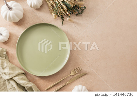Autumn table setting with green plate white pumpkins and dried wheat flat lay Autumn table setting with green plate white pumpkins and dried wheat flat lay 141446736