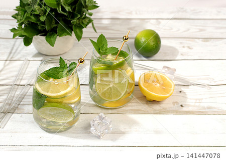 Refreshing summer drink, homemade lemonade, juice or cocktail with ice, mint, lime, lemon and citrus, a detox diet and weight loss concept, a restaurant or cafe menu, nonalcoholic mojito for energy Refreshing summer drink, homemade lemonade, juice or cocktail with ice, mint, lime, lemon and citrus, a detox diet and weight loss concept, a restaurant or cafe menu, nonalcoholic mojito for energy 141447078