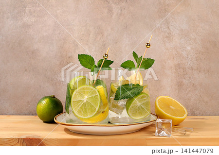 Icy homemade lemonade, juice or cocktail with mint, spearmint, lime, lemon and citrus, a refreshing summer drink recipe, a detox diet and weight loss concept, nonalcoholic mojito for energy Icy homemade lemonade, juice or cocktail with mint, spearmint, lime, lemon and citrus, a refreshing summer drink recipe, a detox diet and weight loss concept, nonalcoholic mojito for energy 141447079
