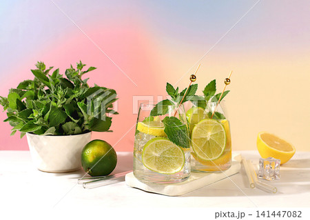 Icy homemade lemonade, juice or cocktail with mint, spearmint, lime, lemon and citrus, a refreshing summer drink recipe, a detox diet and weight loss concept, nonalcoholic mojito for energy Icy homemade lemonade, juice or cocktail with mint, spearmint, lime, lemon and citrus, a refreshing summer drink recipe, a detox diet and weight loss concept, nonalcoholic mojito for energy 141447082