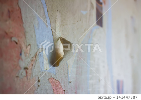 Distressed wall with exposed plaster and old wallpaper fragments ready for surface repair and refinishing. Distressed wall with exposed plaster and old wallpaper fragments ready for surface repair and refinishing. 141447587
