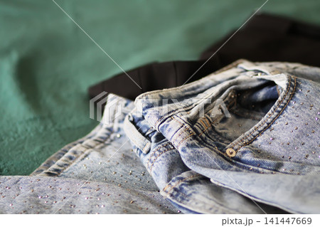Messy clothing spread across a bedroom floor in an untidy domestic setting. Messy clothing spread across a bedroom floor in an untidy domestic setting. 141447669
