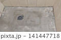 Preparing a shower area base during bathroom renovation, with cement mortar being used to level the floor surface and install a drainage system. Construction materials, plumbing elements, and wet room 141447718