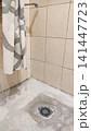 Preparing a shower area base during bathroom renovation, with cement mortar being used to level the floor surface and install a drainage system. Construction materials, plumbing elements, and wet room 141447723