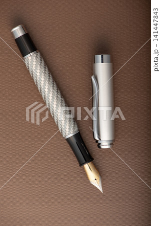 Fountain pen, beautiful fountain pen with detailed design on a brown synthetic leather surface, selective focus. 141447843