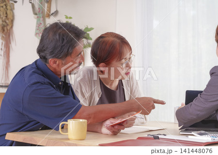 年金受給の説明を受ける熟年夫婦 年金受給の説明を受ける熟年夫婦 141448076