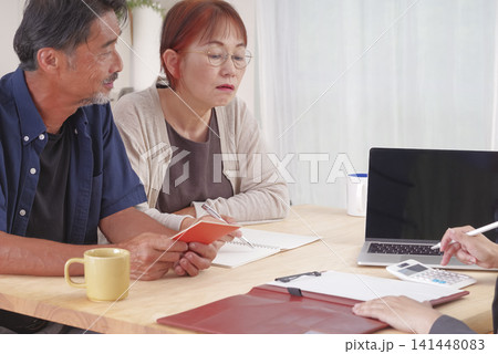 年金受給の説明を受ける熟年夫婦 年金受給の説明を受ける熟年夫婦 141448083