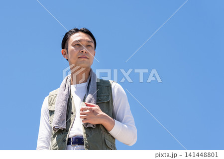 青空を背景に立つ作業着姿の男性作業員 青空を背景に立つ作業着姿の男性作業員 141448801