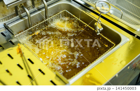 Commercial deep fryer with bubbling hot oil in a professional restaurant kitchen 141450003
