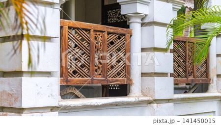 Traditional colonial villa window with carved wooden lattice panels Traditional colonial villa window with carved wooden lattice panels 141450015