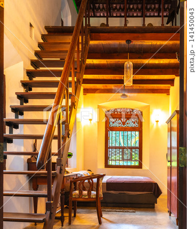 Cozy loft bedroom with wooden staircase and warm ambient lighting 141450043
