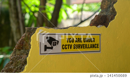 CCTV surveillance warning sign on a yellow wall 141450089