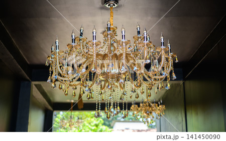 Luxurious crystal chandelier hanging. Interior with sparkling decorative lighting Luxurious crystal chandelier hanging. Interior with sparkling decorative lighting 141450090