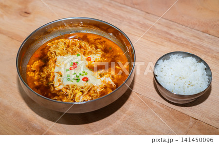 Spicy Korean ramen noodles with egg served alongside steamed white rice on a wooden table Spicy Korean ramen noodles with egg served alongside steamed white rice on a wooden table 141450096