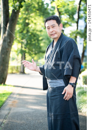 着物を着て案内する男性 141450471