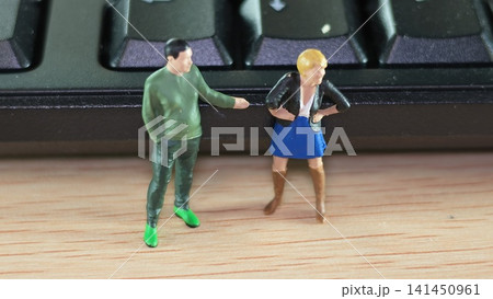 Miniature Couple Standing Beside Computer Keyboard Edge 141450961