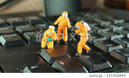 Miniature Hazmat Workers Cleaning Computer Keyboard Surface Miniature Hazmat Workers Cleaning Computer Keyboard Surface 141450964
